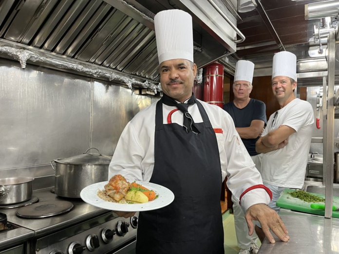 Yasser, le chef, présente un pigeon farci lors d'un cours de cuisine avec les passagers (©PB)