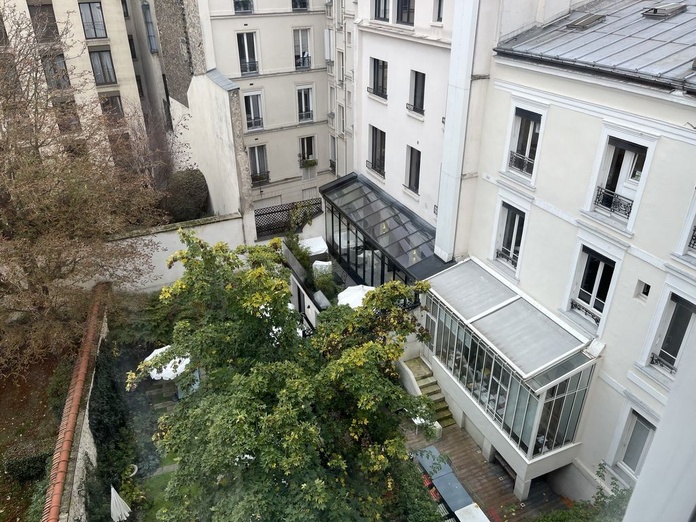 Entre les deux immeubles où est installée Maison Boissière, un joli jardin à l'italienne. Au fond, au premier étage, un appartement de prestige avec sa verrière noire (©PB)