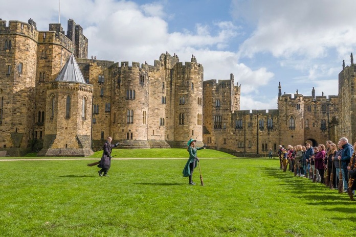 Des visiteurs s'initient à l'art de chevaucher un balai avec des professeurs-sorciers (©Alnwick Castle)