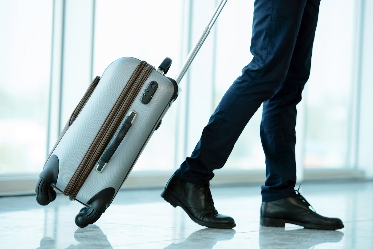 Homme D'affaires Du Moyen-orient En Voyage D'affaires Portant Une Valise à  L'aéroport Avec Tableau Des Horaires De Vol