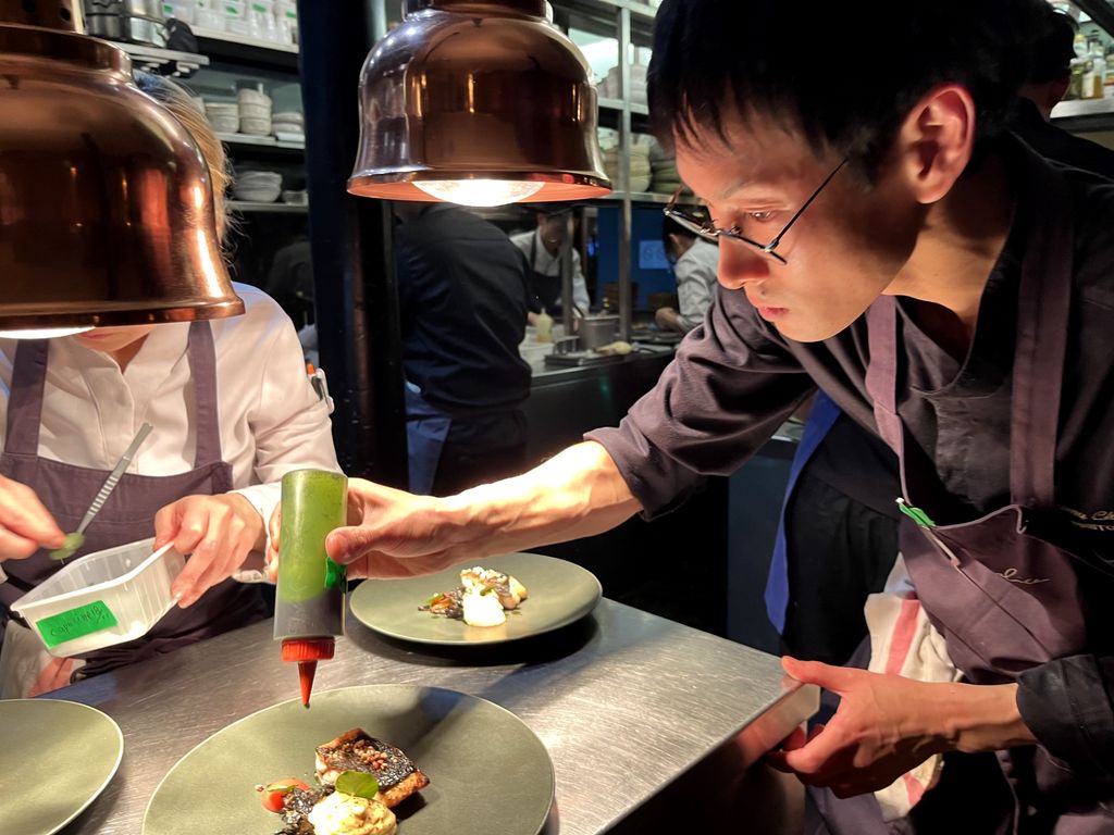 Le chef  Kazuma Chikuda en train de dresser le plat de poisson servi au dîner parisien de la préfecture de Nagano (©Paula Boyer)